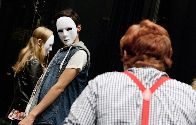 Teaterelever som har masker på sig.