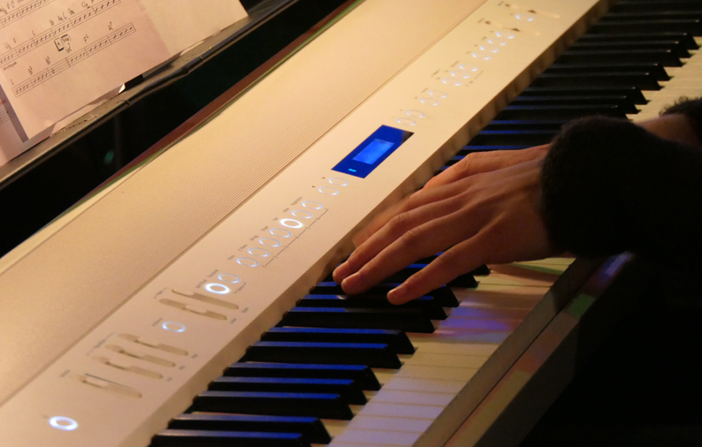 Musikelev spelar på ett elpiano.